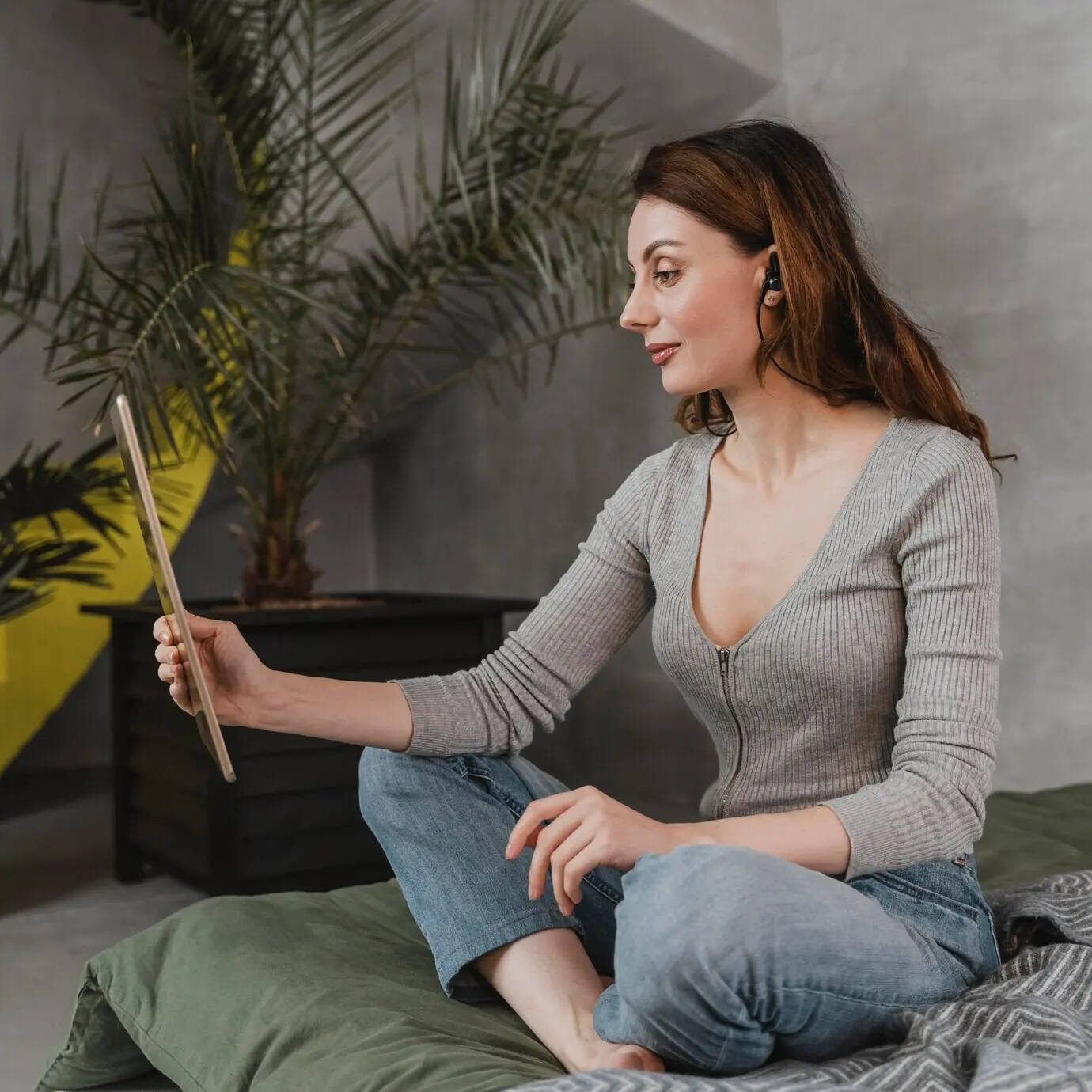 Full-length shot of a woman with a tablet and earphones.